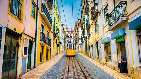 A tram travelling down a street in Lisbon, Portugal